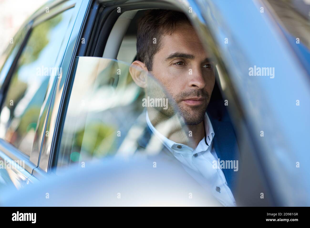 Giovane uomo seduto in questa macchina in città Foto Stock