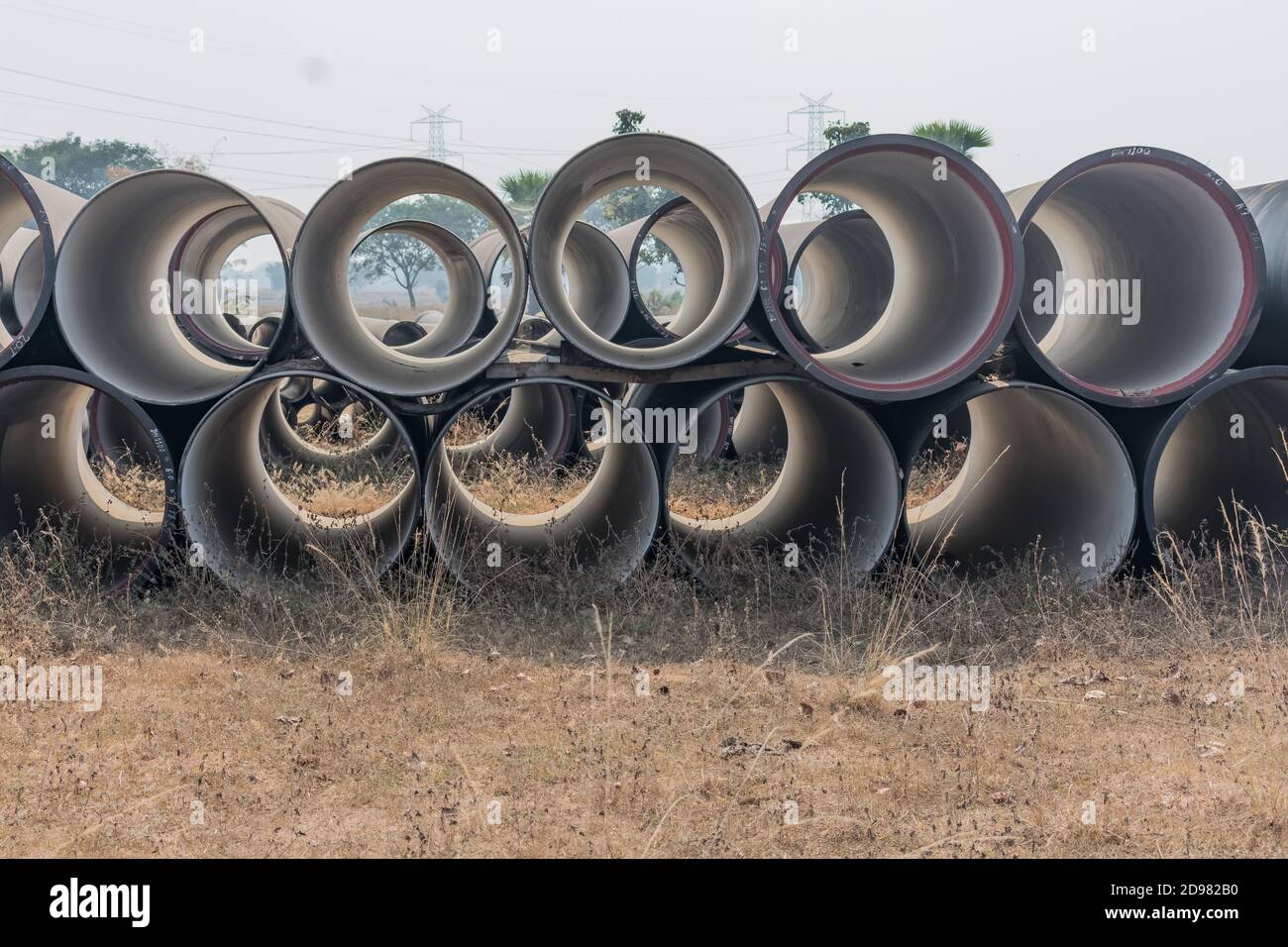 vista laterale dei tubi di ferro duttile immagazzinati in deposito di spazio aperto deposito. Foto Stock