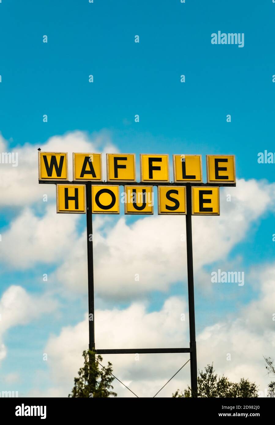 Waffle casa segnale stradale set contro un cielo blu con nuvole nel cielo. Foto Stock
