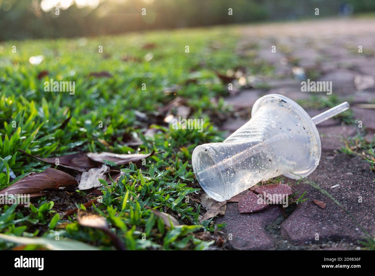 Le tazze in PVC cucciolate sul parco pubblico rappresentano un pericolo per l'ambiente Foto Stock