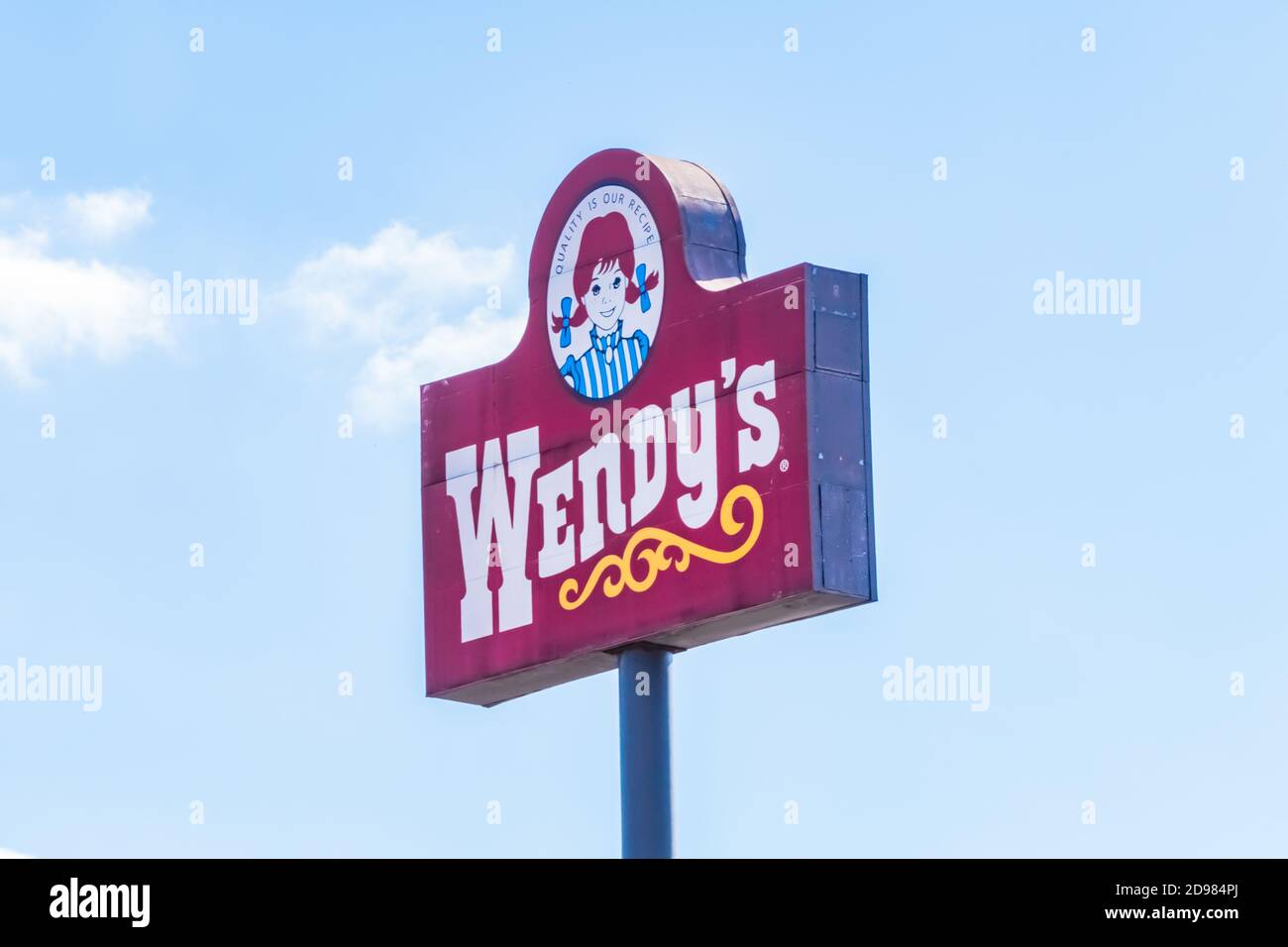 Il cartello stradale del ristorante fast food Wendy's si trova contro un cielo blu con nuvole bianche. Foto Stock