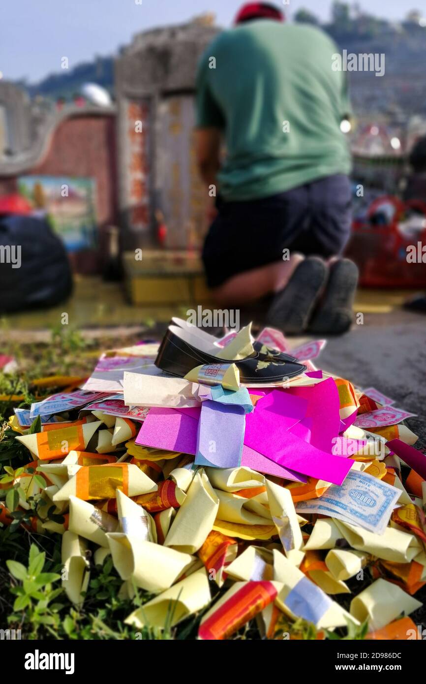 Bruciate offrendo denaro di carta e oro agli antenati durante il Qingming Foto Stock