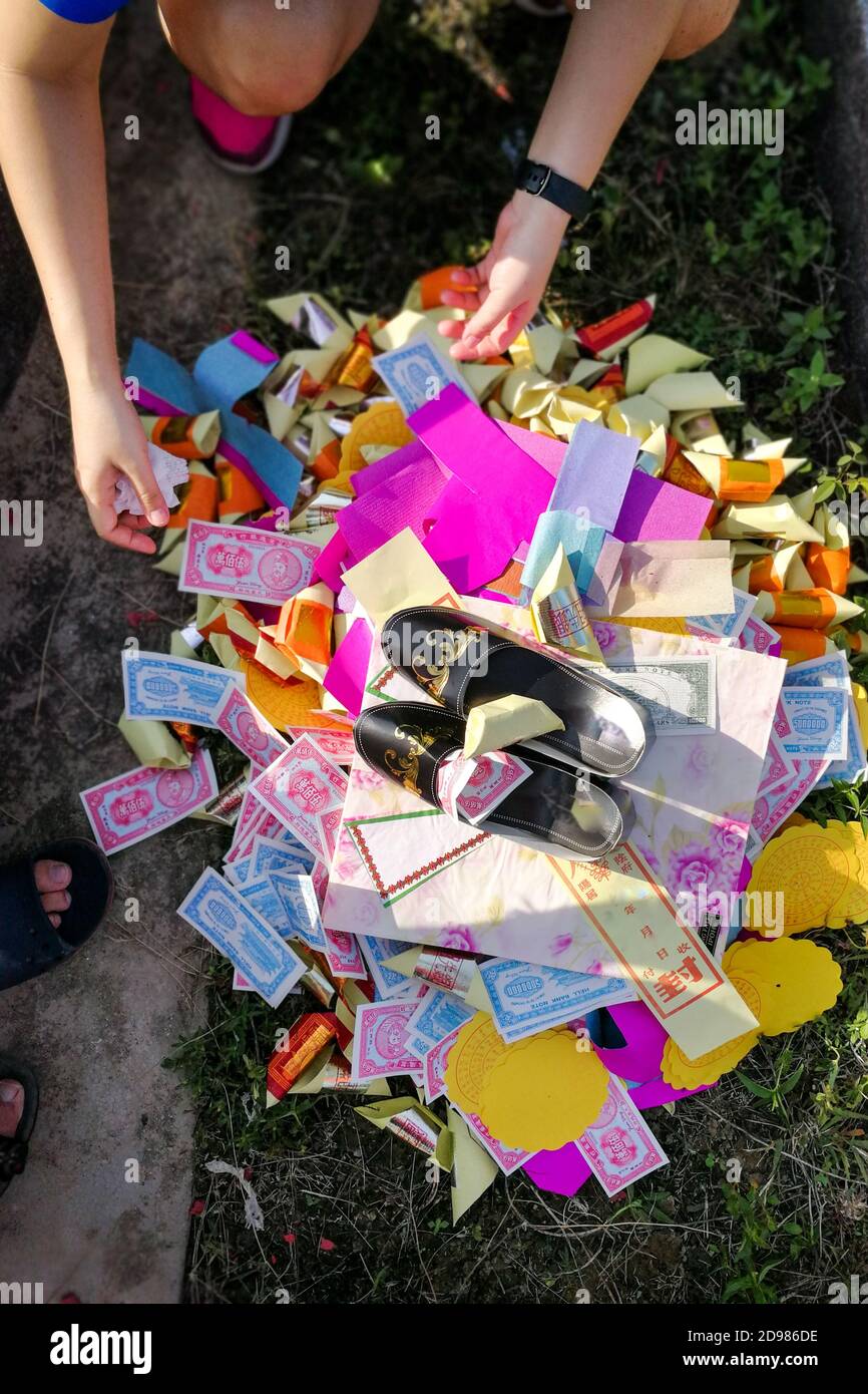 Bruciate offrendo denaro di carta e oro agli antenati durante il Qingming Foto Stock