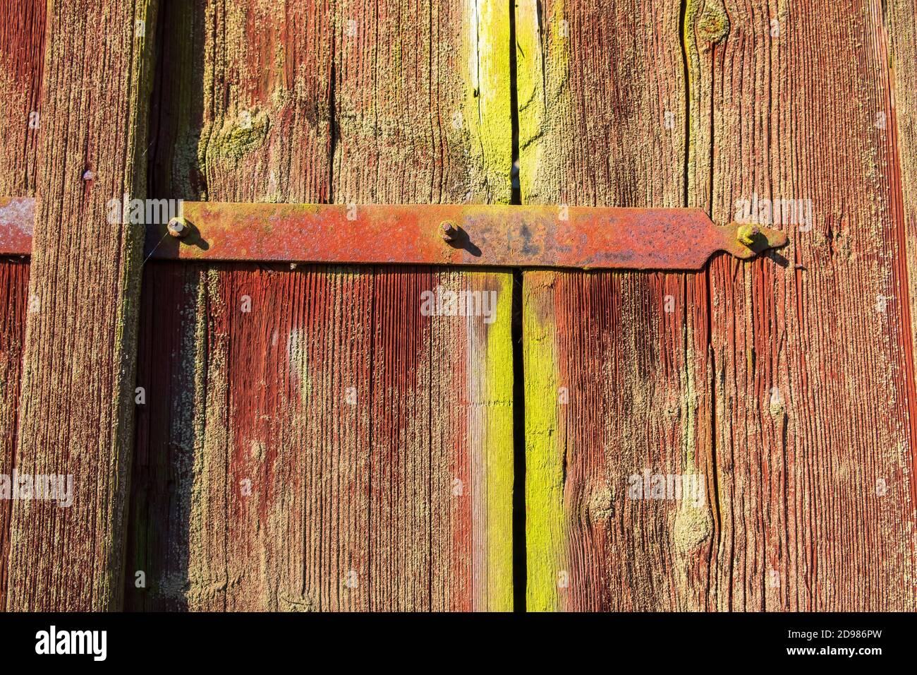 Cerniere su una vecchia porta di legno rosso Foto Stock