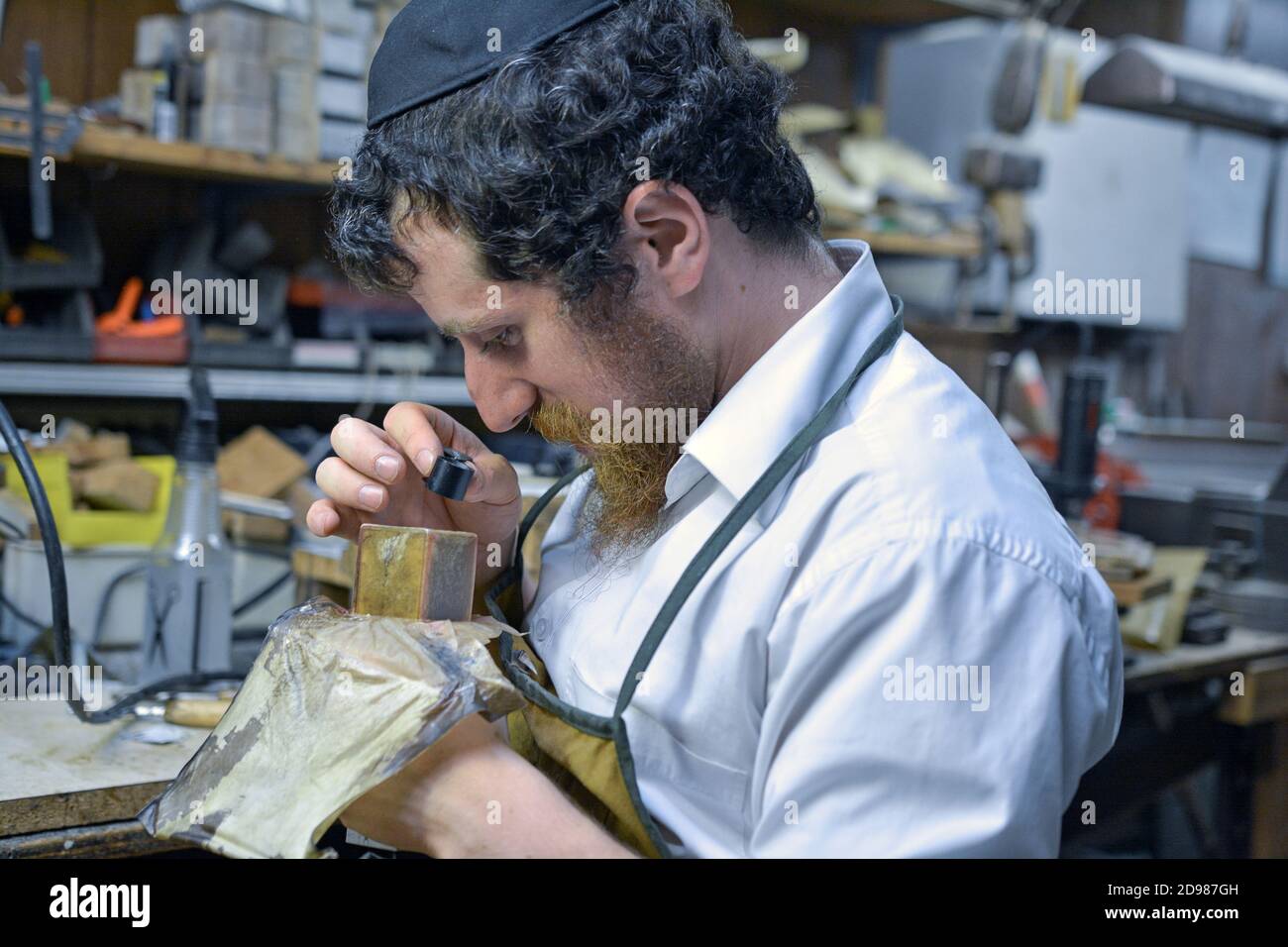 Nel suo laboratorio, un rabbino & maestro artigiano fa filatterie (tefillin) da utilizzare da ebrei ortodossi durante i parayers del mattino. A Brooklyn, New York C. Foto Stock