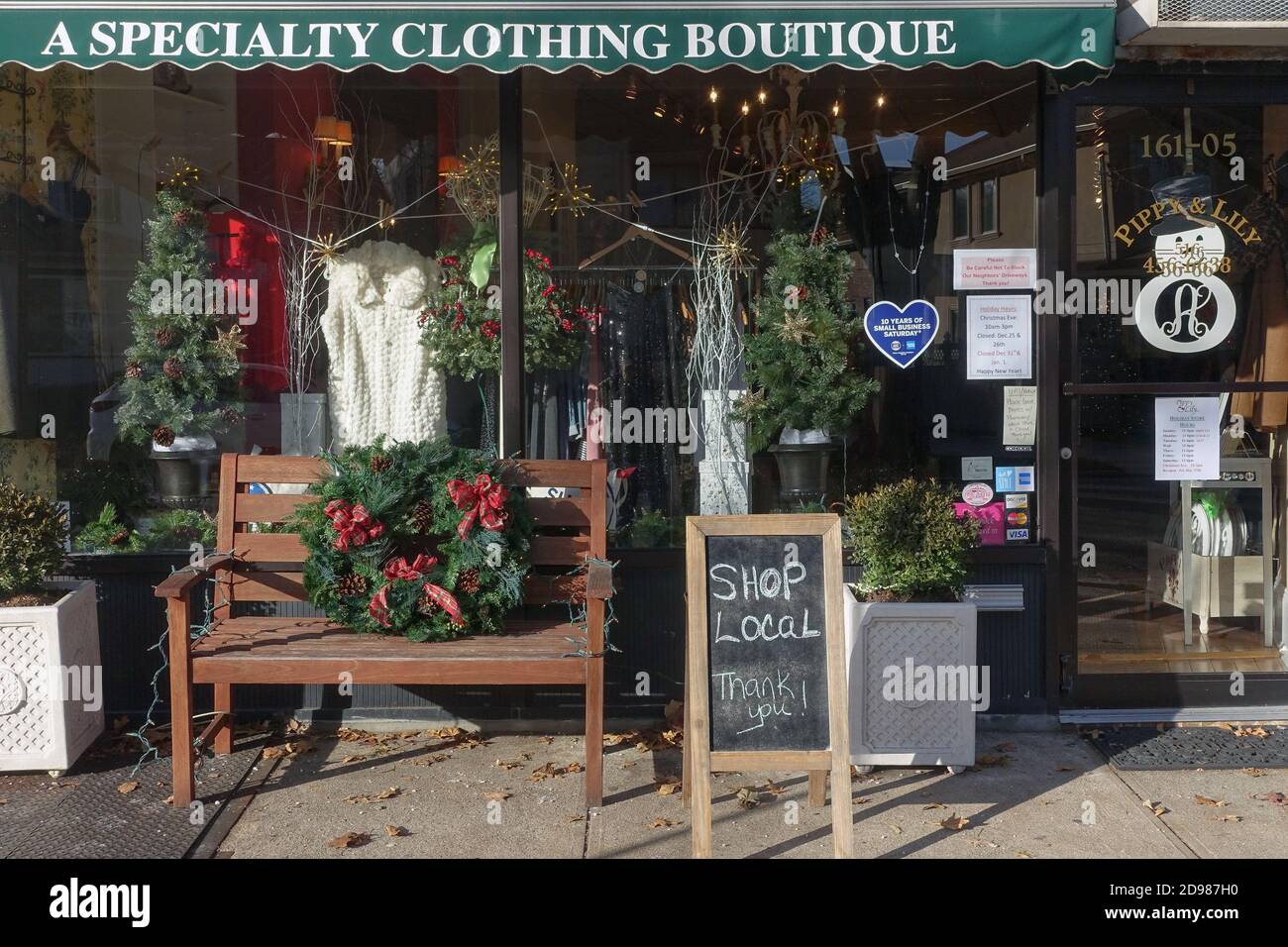 NEGOZIO LOCALE. L'esterno di un piccolo negozio di abbigliamento femminile di quartiere con un cartello che incoraggia le persone a fare acquisti locali. A Flushing, Queens, New York. Foto Stock