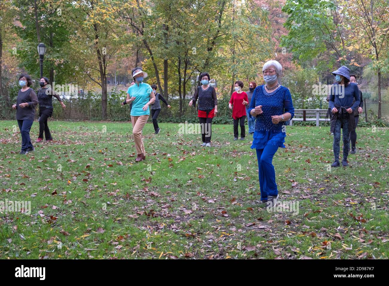 Un gruppo di donne asiatiche americane di tutte le età indossa maschere e distanza sociale. In una lezione di danza in un parco a Flushing, Queens, New York City. Foto Stock
