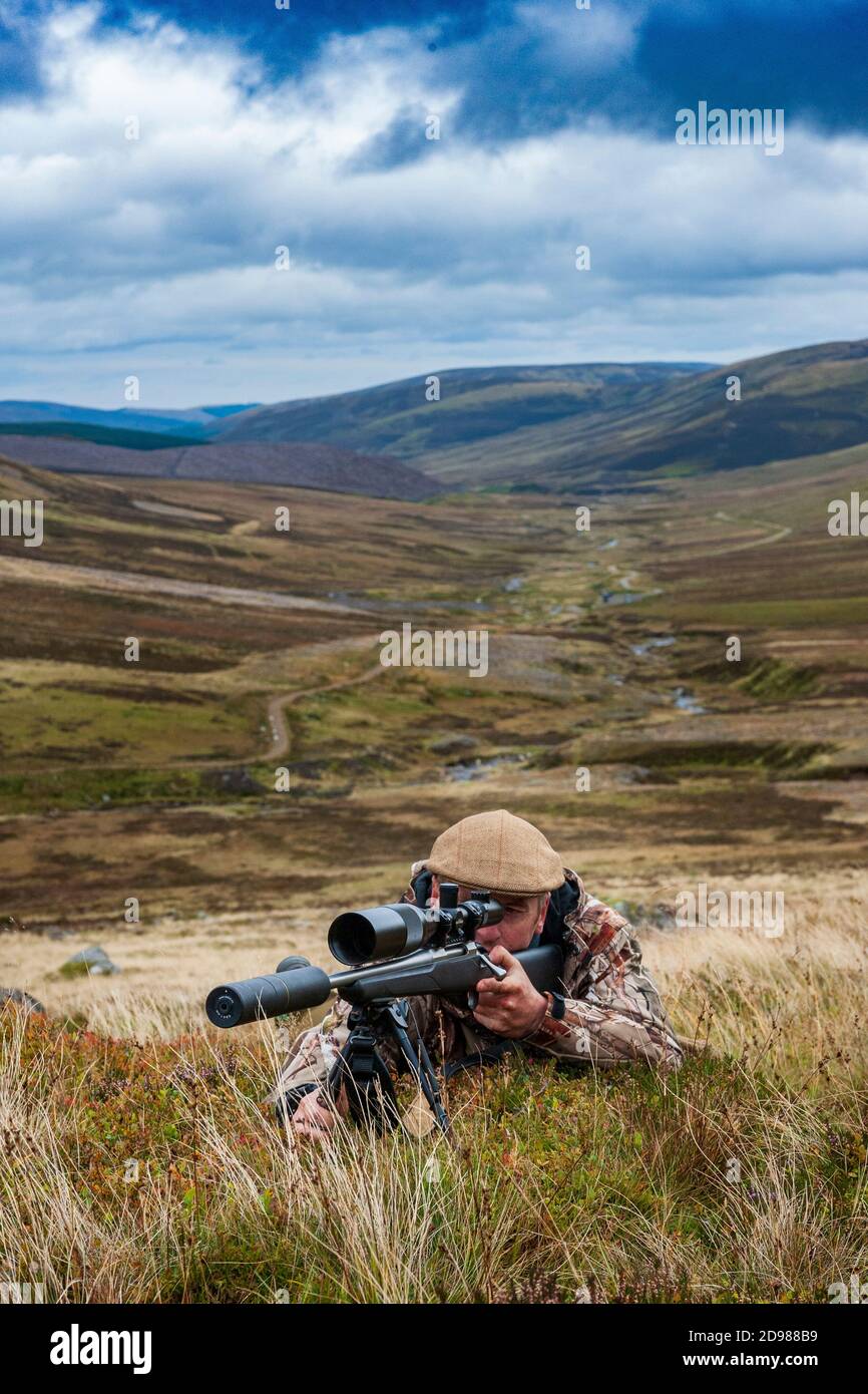 Scozia, Regno Unito – UN deerstalker nelle Highlands scozzesi in cerca di un Red Deer Stag durante la stagione di abbattimento Foto Stock