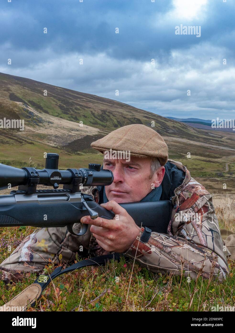 Scozia, Regno Unito – UN deerstalker nelle Highlands scozzesi in cerca di un Red Deer Stag durante la stagione di abbattimento Foto Stock