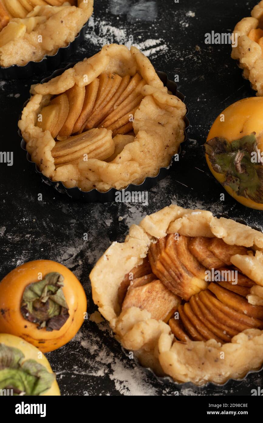 Preparare la torta dolce autunnale con i persimmons crudi Foto Stock