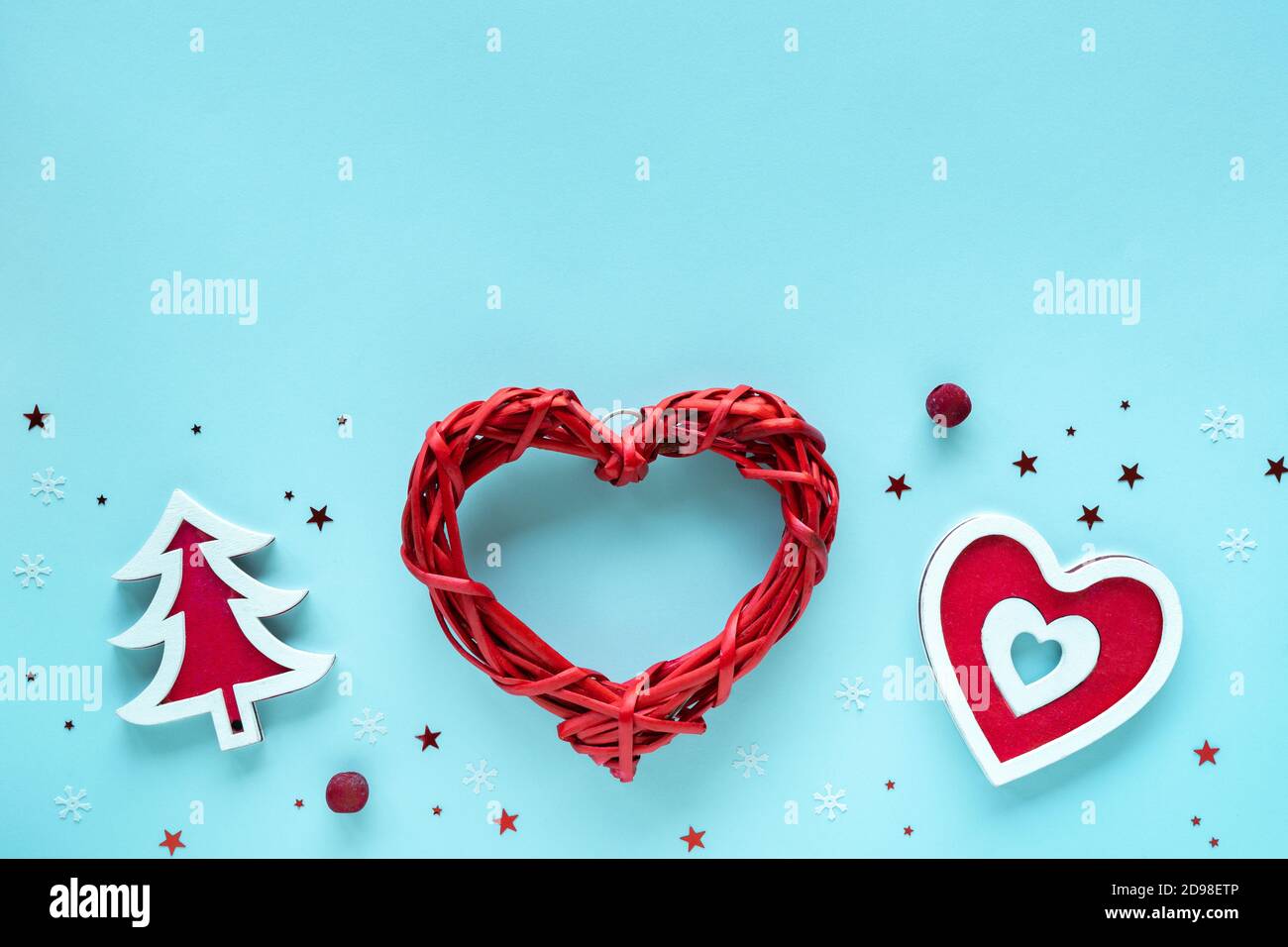 Composizione natalizia con decorazioni rosse e bianche su superficie blu pastello, vista dall'alto, spazio copia. Buon Natale e buon Natale biglietto d'auguri Foto Stock