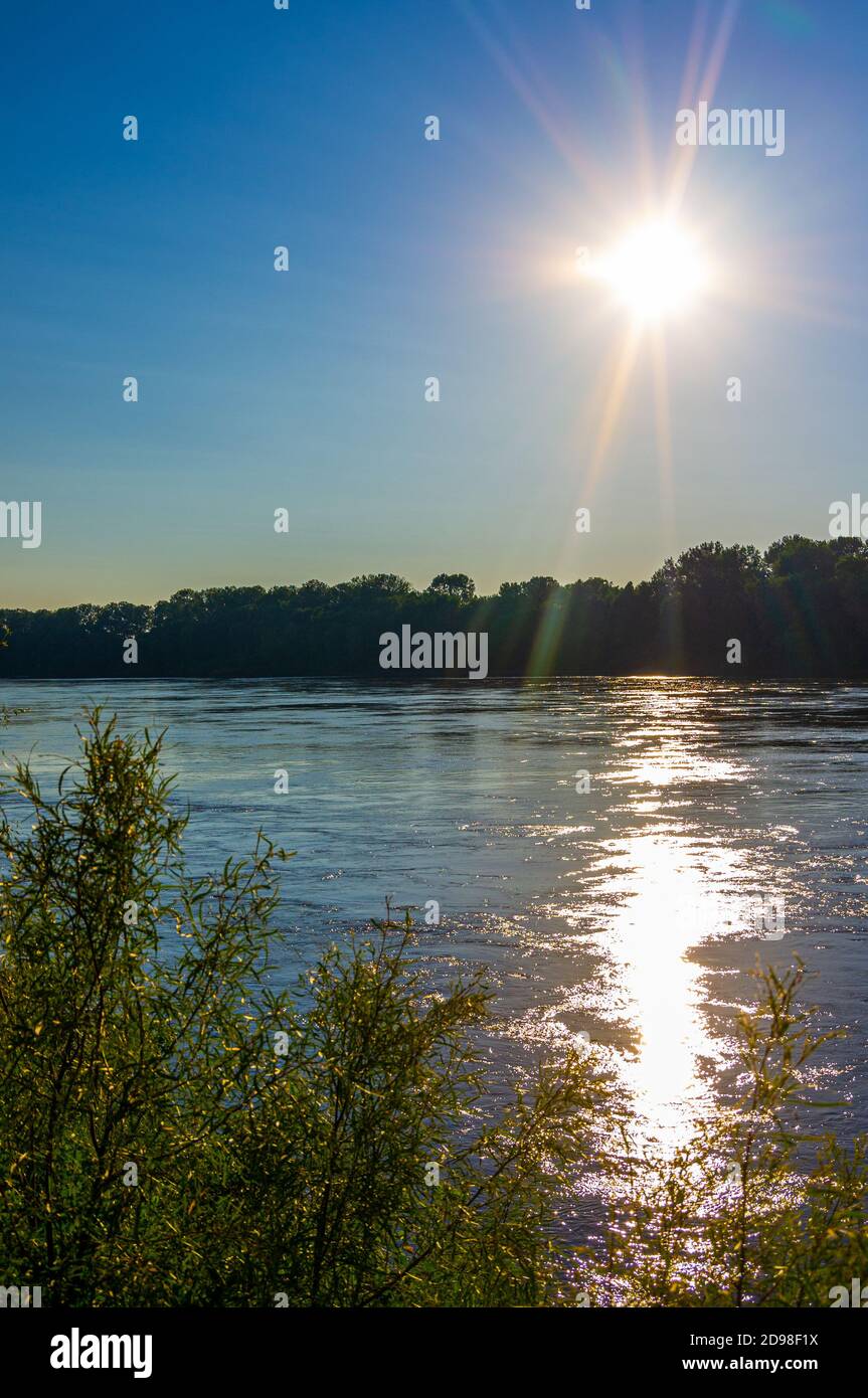 Tramonto sulla confluenza del Missouri e del fiume Mississippi vicino a Saint Louis con luce che si riflette di increspature sull'acqua e gli alberi sullo sfondo Foto Stock