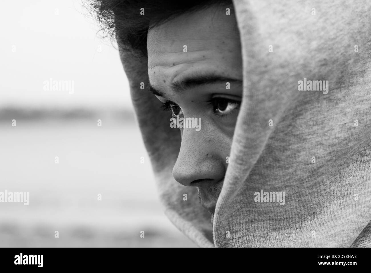 Giovane adulto in posa sulla costa Foto Stock