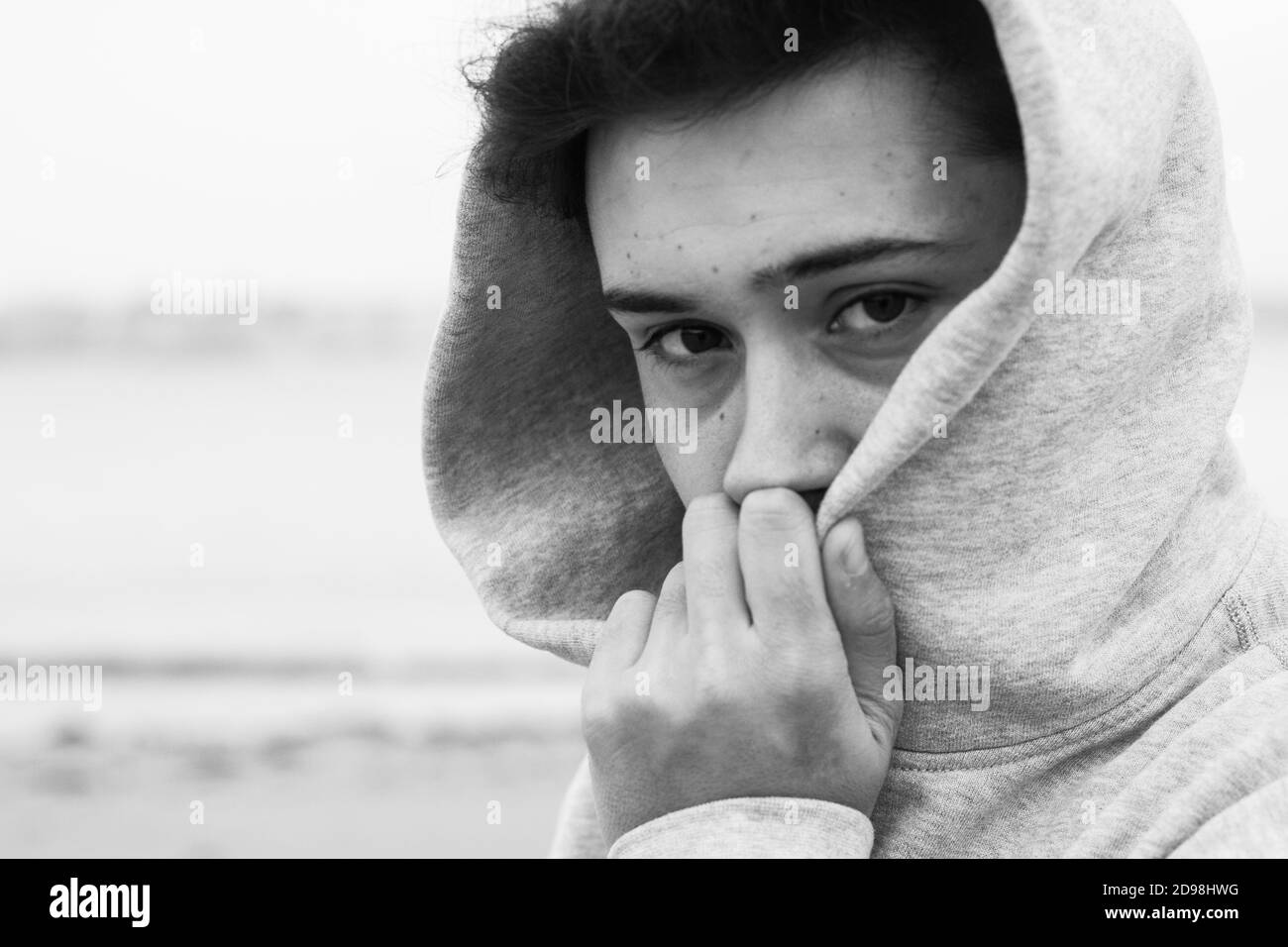 Giovane adulto in posa sulla costa Foto Stock