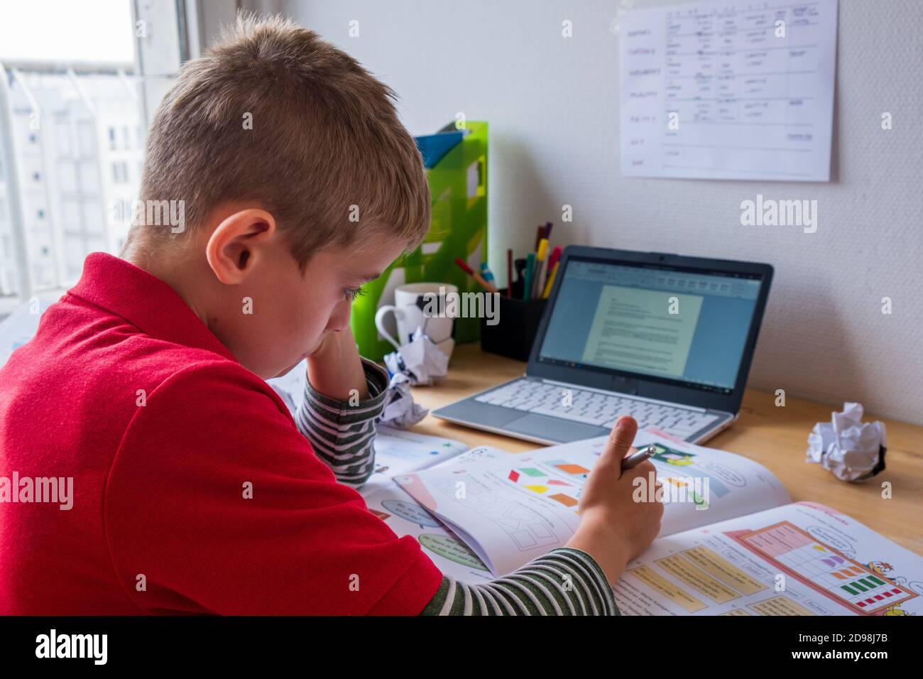 Ragazzo che si concentra durante il homeschooling nel blocco corona Foto Stock