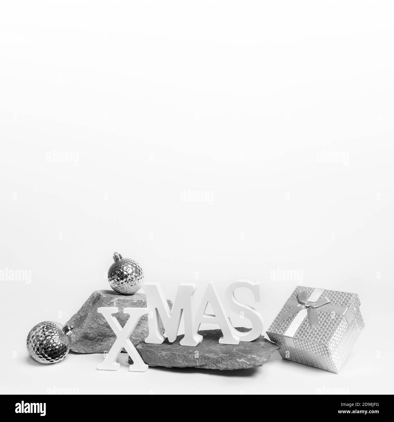 Decorazioni di Natale su pietra si erge su bianco. Natale festoso moderno e alla moda composizione monocromatica con spazio per la copia. Foto Stock