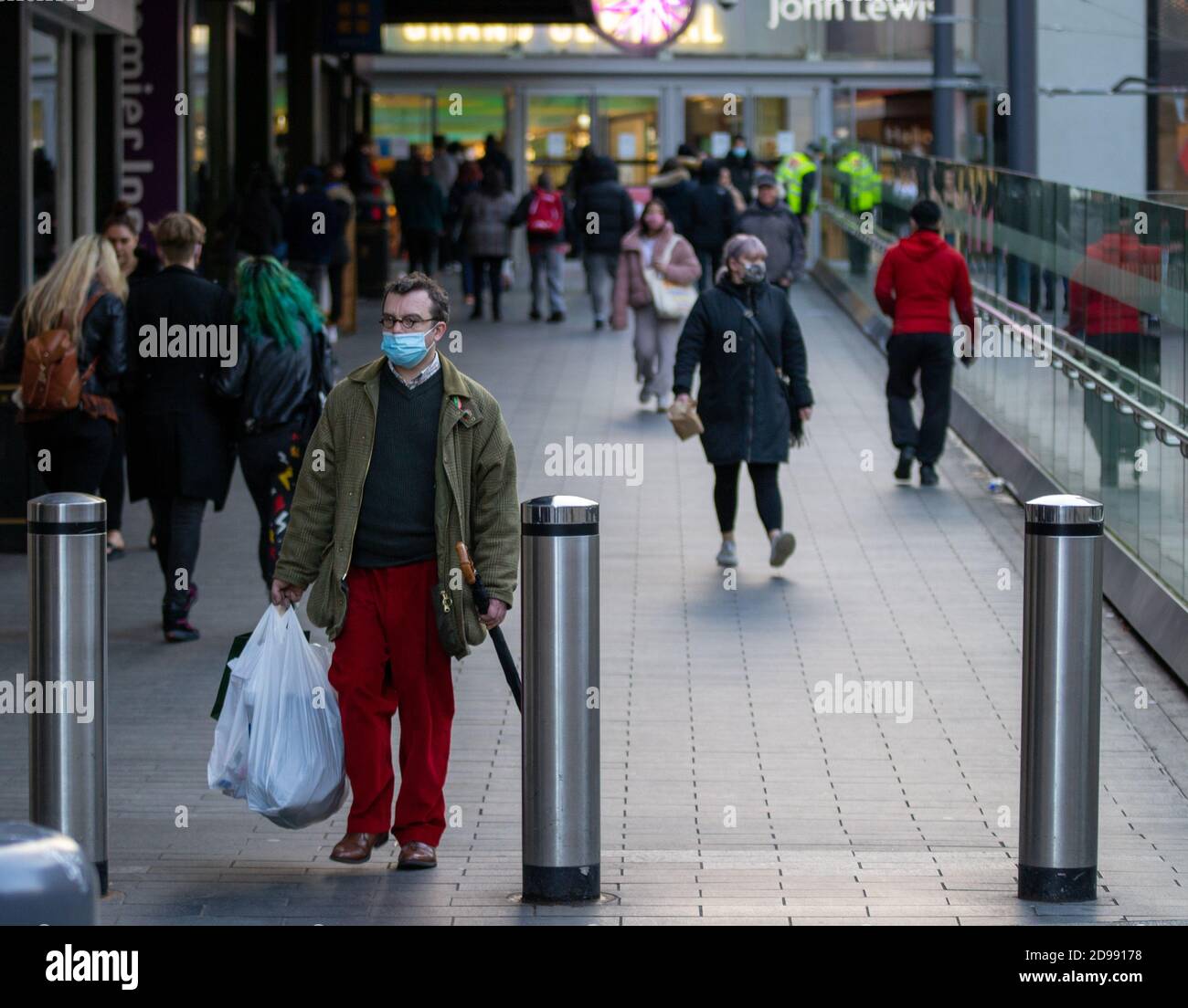 Un uomo porta il suo shopping lungo la rampa alla stazione ferroviaria Grand Central di Birmingham su New Street. Birmingham, Regno Unito. Foto Stock