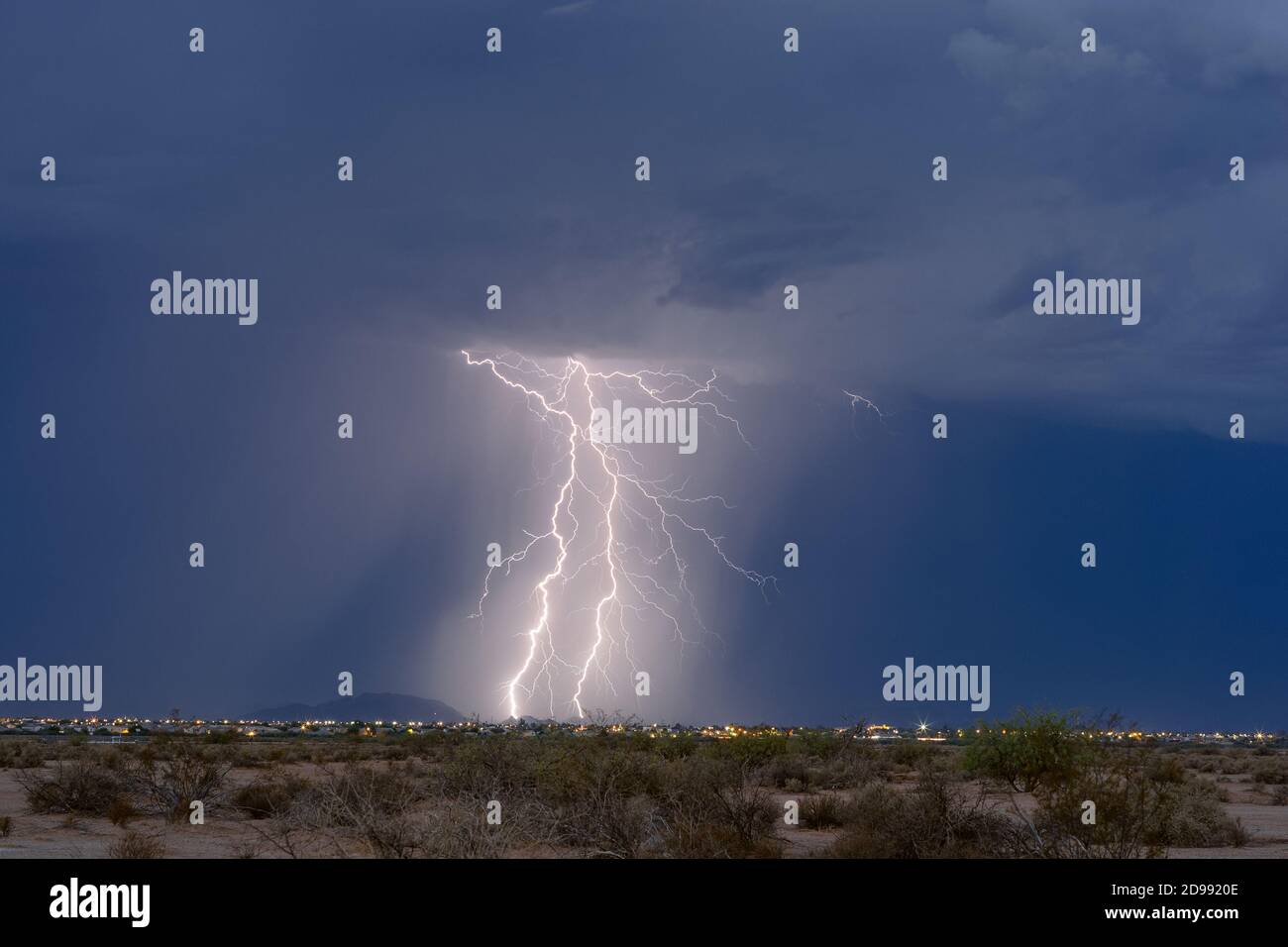 Un paio di fulmini colpiscono una montagna mentre un temporale si avvicina a Casa Grande, Arizona Foto Stock