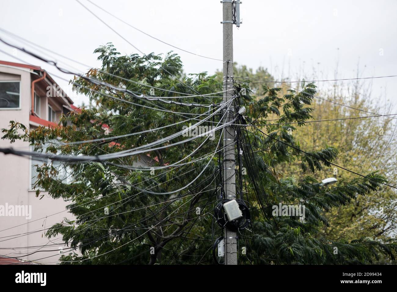 Molti cavi internet e TV non organizzati su un palo di cemento a Bucarest. Foto Stock