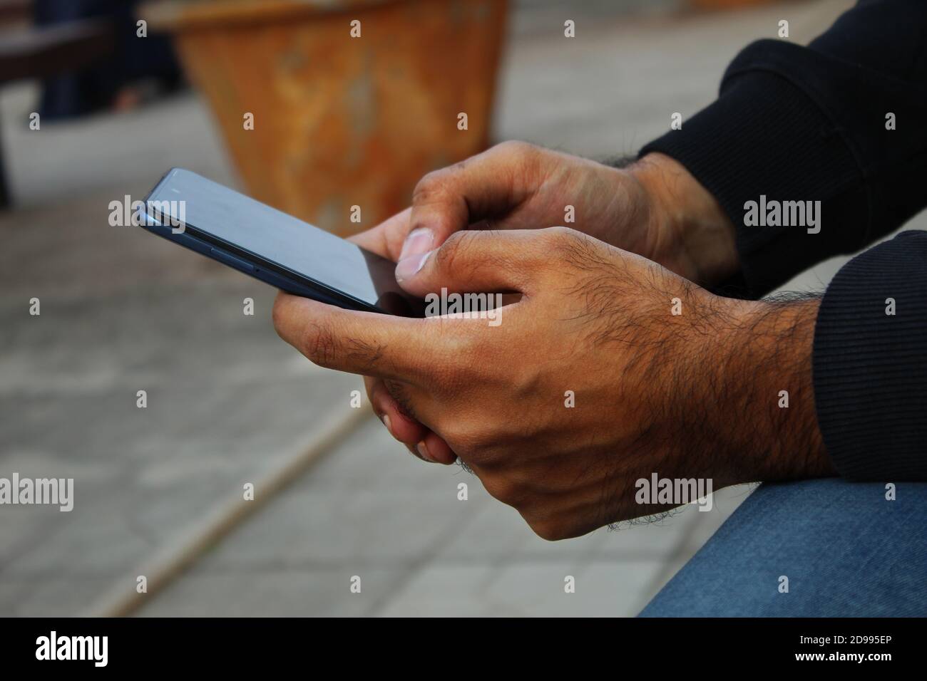 Closeup delle mani dell'uomo di pelle scura di mezza età con android pona Foto Stock