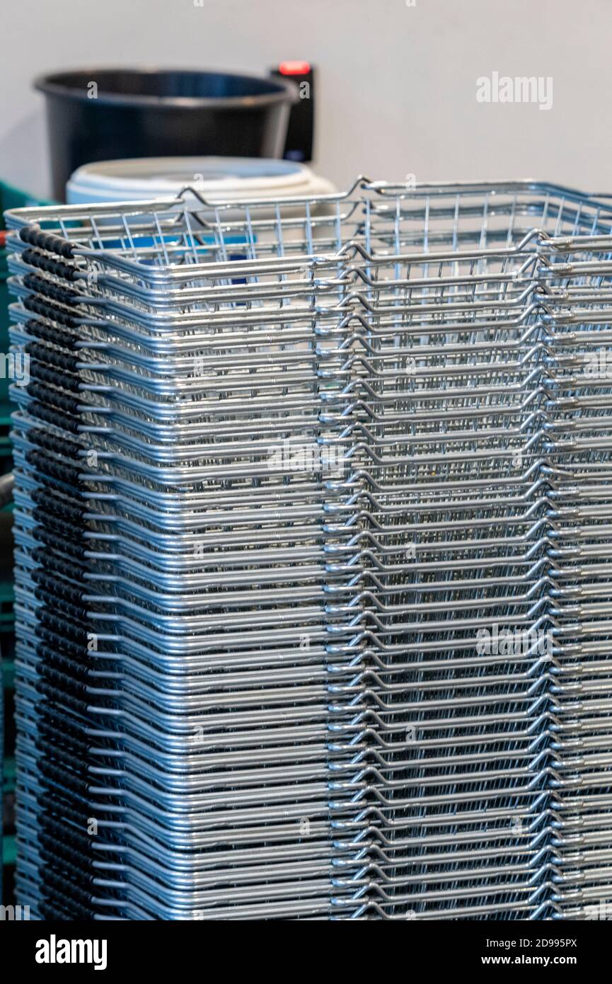 pila di cestini in attesa di essere utilizzati al di fuori di un supermercato per il trasporto settimanale di shopping. Foto Stock