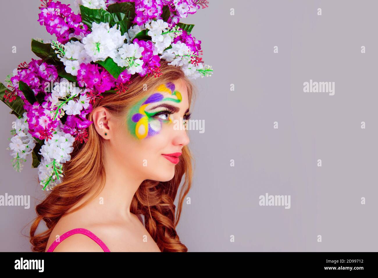 Bella giovane donna con fascia floreale in fiori lilla sul profilo laterale – isolato su sfondo viola chiaro. lan corpo espreesione volto umano positivo Foto Stock