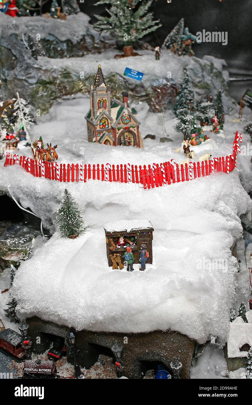 Un modello di scena del villaggio di Natale, una chiesa con un recinto rosso picket, in un paese delle meraviglie invernali. ©PRWFotografia Foto Stock