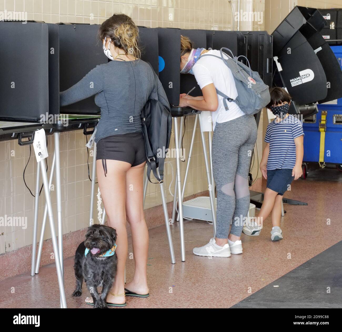 Miami, Stati Uniti. 03 Nov 2020. I residenti della Florida si trovano alla cabina di voto mentre suo figlio gioca con il suo iPhone il giorno delle elezioni per votare alle elezioni presidenziali del 2020 alla stazione dei vigili del fuoco di Miami 2 a Miami, Florida martedì 3 novembre 2020. Le linee dei siti di scrutinio sono più brevi del normale a causa del numero di elettori che hanno votato in anticipo o hanno utilizzato i voti per posta. La distanza sociale è in vigore a causa della pandemia di COVID-19. Foto di Gary i Rothstein/UPI Credit: UPI/Alamy Live News Foto Stock
