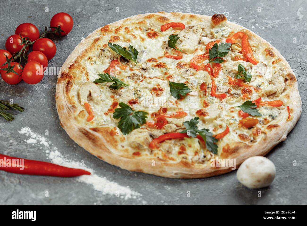Pizza blu di pollo con pomodoro, mozzarella e formaggi Dor Blue su sfondo grigio Foto Stock