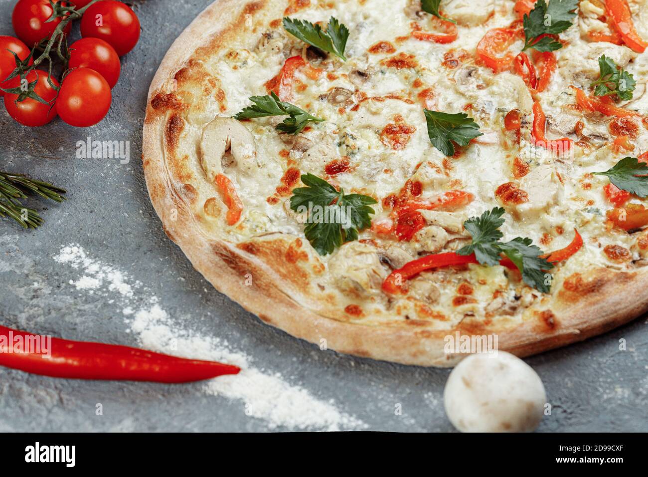 Pizza blu di pollo con pomodoro, mozzarella e formaggi Dor Blue su sfondo grigio Foto Stock