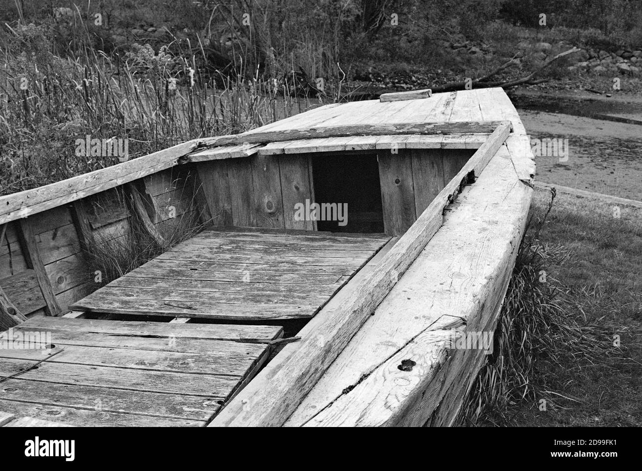 Una barca di legno bianco d'epoca abbandonata riposa in erba alta sulla riva del fiume Saugus presso la Saugus Iron Works. La Saugus Iron Works (originariamente Foto Stock