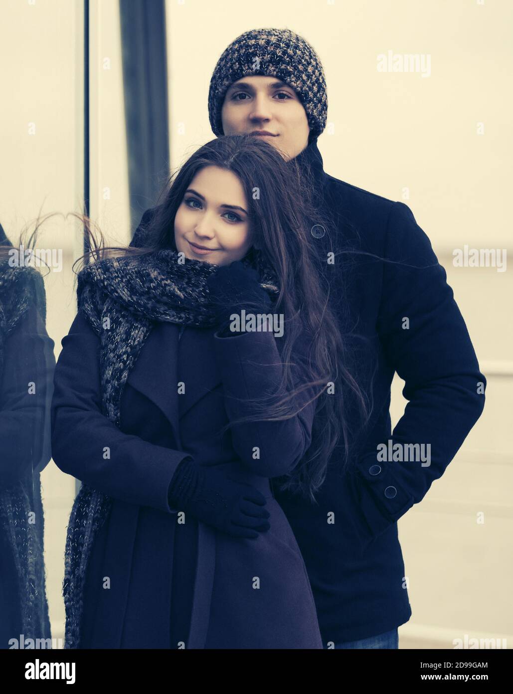 Felice giovane coppia di moda in amore uomo e donna alla moda indossando cappotti classici, bania e sciarpa Foto Stock