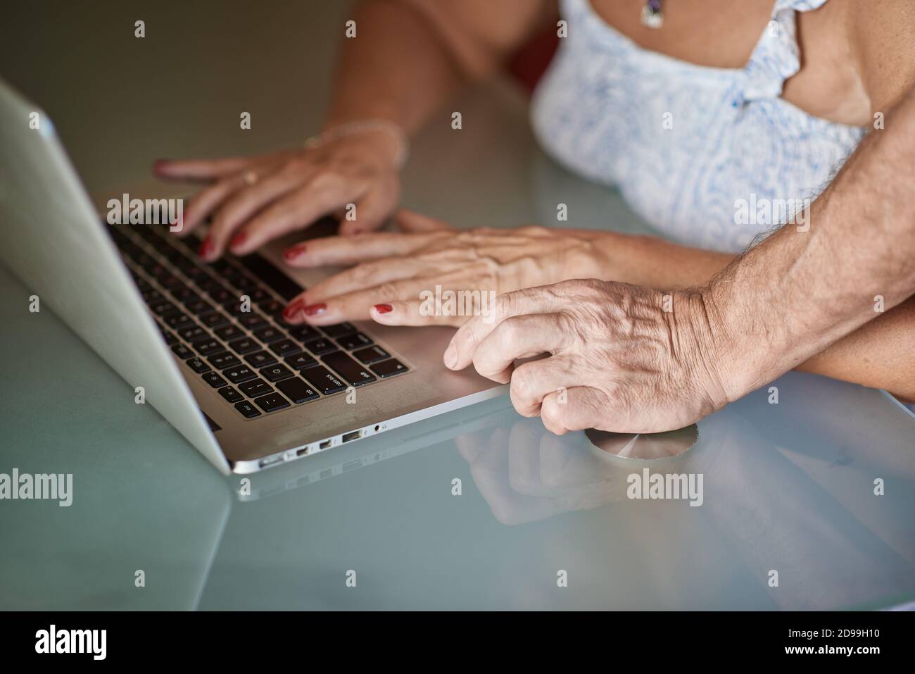 Primo piano delle mani di un uomo adulto e di un donna sul laptop Foto Stock