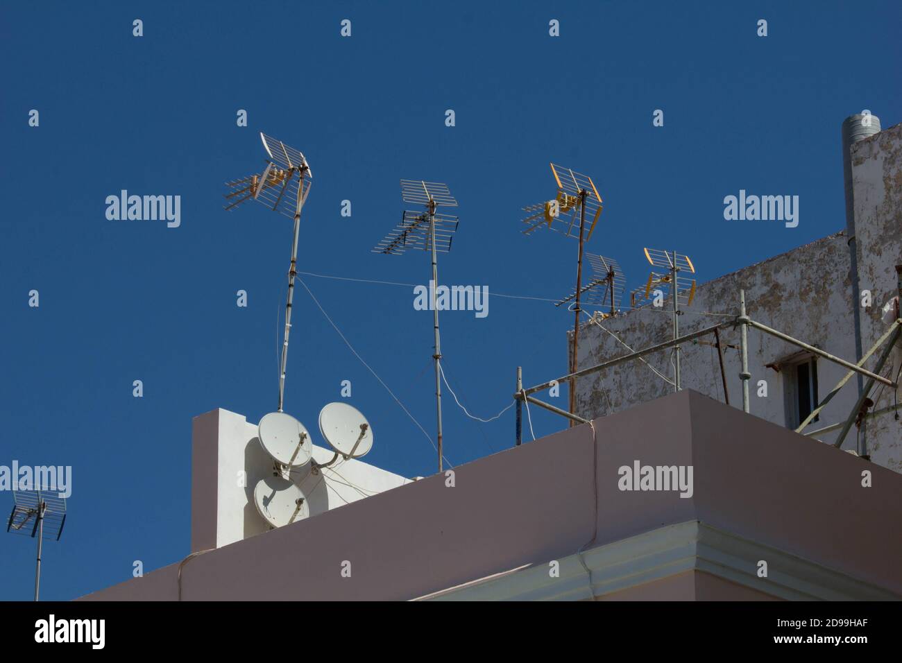 Antenne televisive e piatti satellitari contro un cielo blu. Cartagena, Spagna Foto Stock
