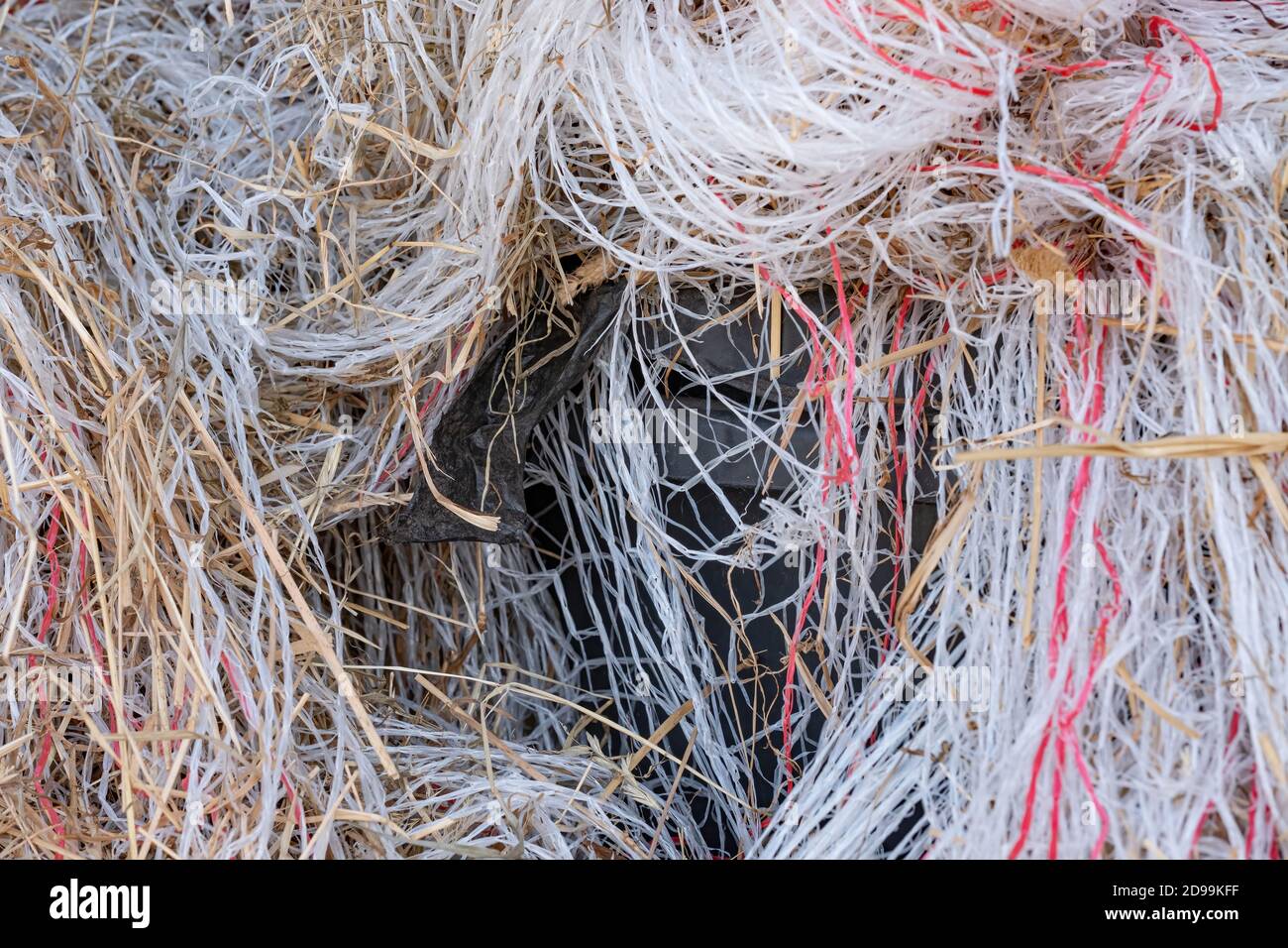 Mucchio di rifiuti, fili di plastica di materiale di imballaggio in un palo grande. Molti colori di plastica di spreco fuori su una fattoria Foto Stock