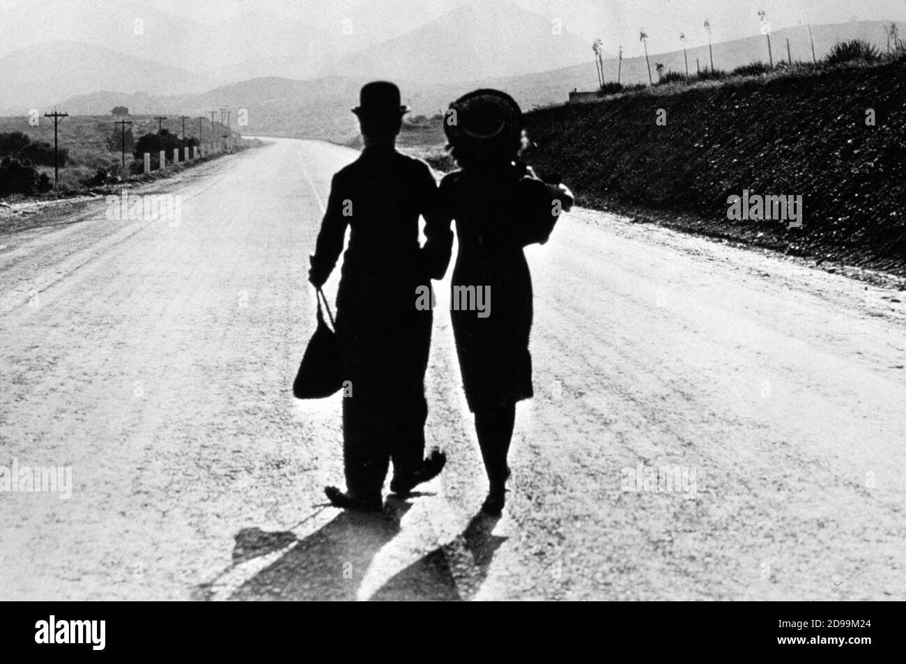 CHARLES CHAPLIN ( 1889 - 1977 ) e Paulette Goddard ( 1911 - 1990 ) in EPOCA MODERNA ( 1936 - tempi moderni ) - vagabondo - vagabondo - CHARLOT - bombetta - cappello bowler - derby ---- Archivio GBB Foto Stock