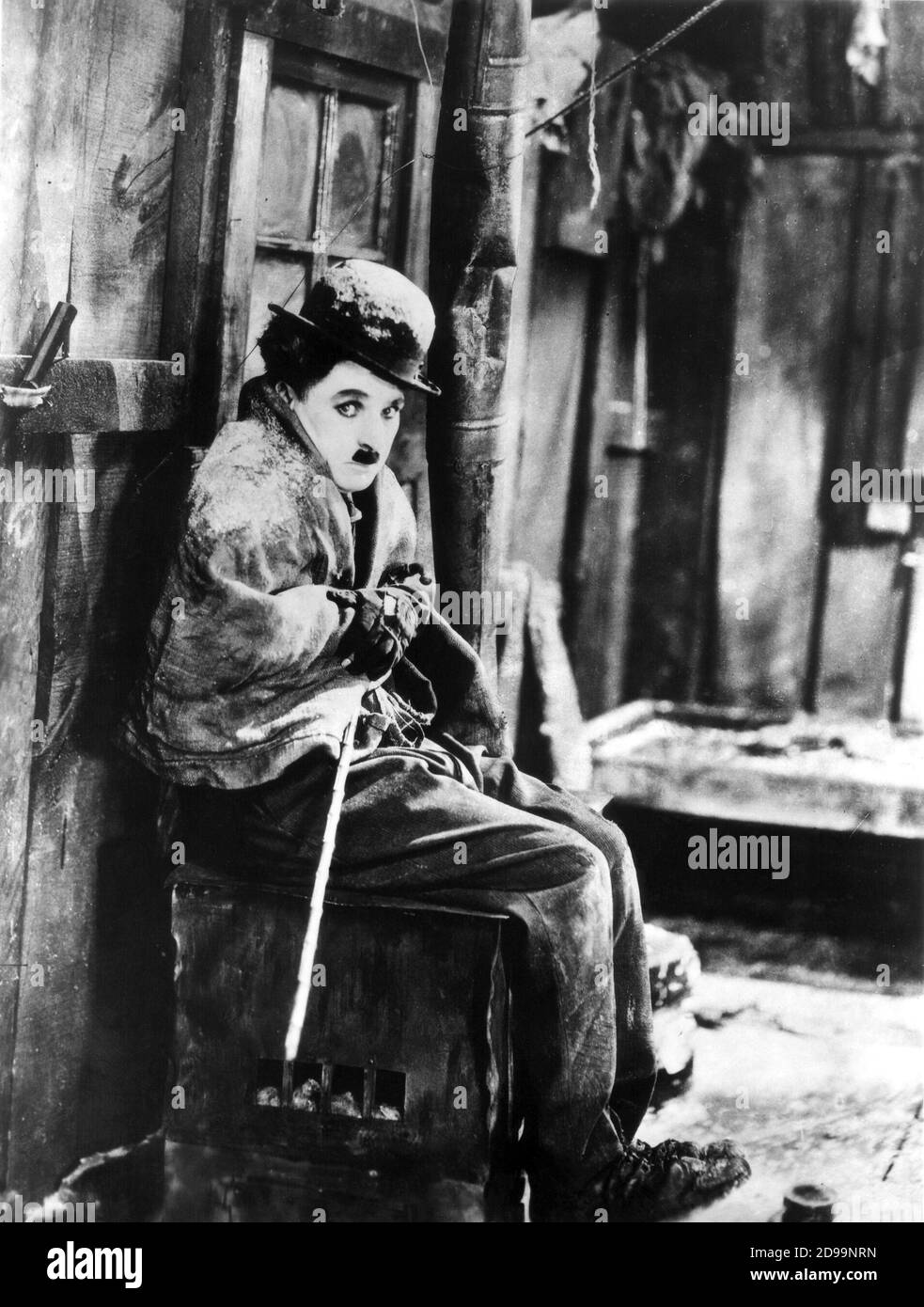 CHARLES CHAPLIN ( 1889 - 1977 ) come Charlot nel GLOD RUSH ( 1925 - la festa dell' oro ) - film muto - CINEMA MUTO - attore - attore - registrazione - regista cinematografico - Alaska - neve - cappello derby - cappello - cappello - bombetta - baffi - baffi - guanti - guanti - guanto - bastone - canna ---- Archivio GBB Foto Stock