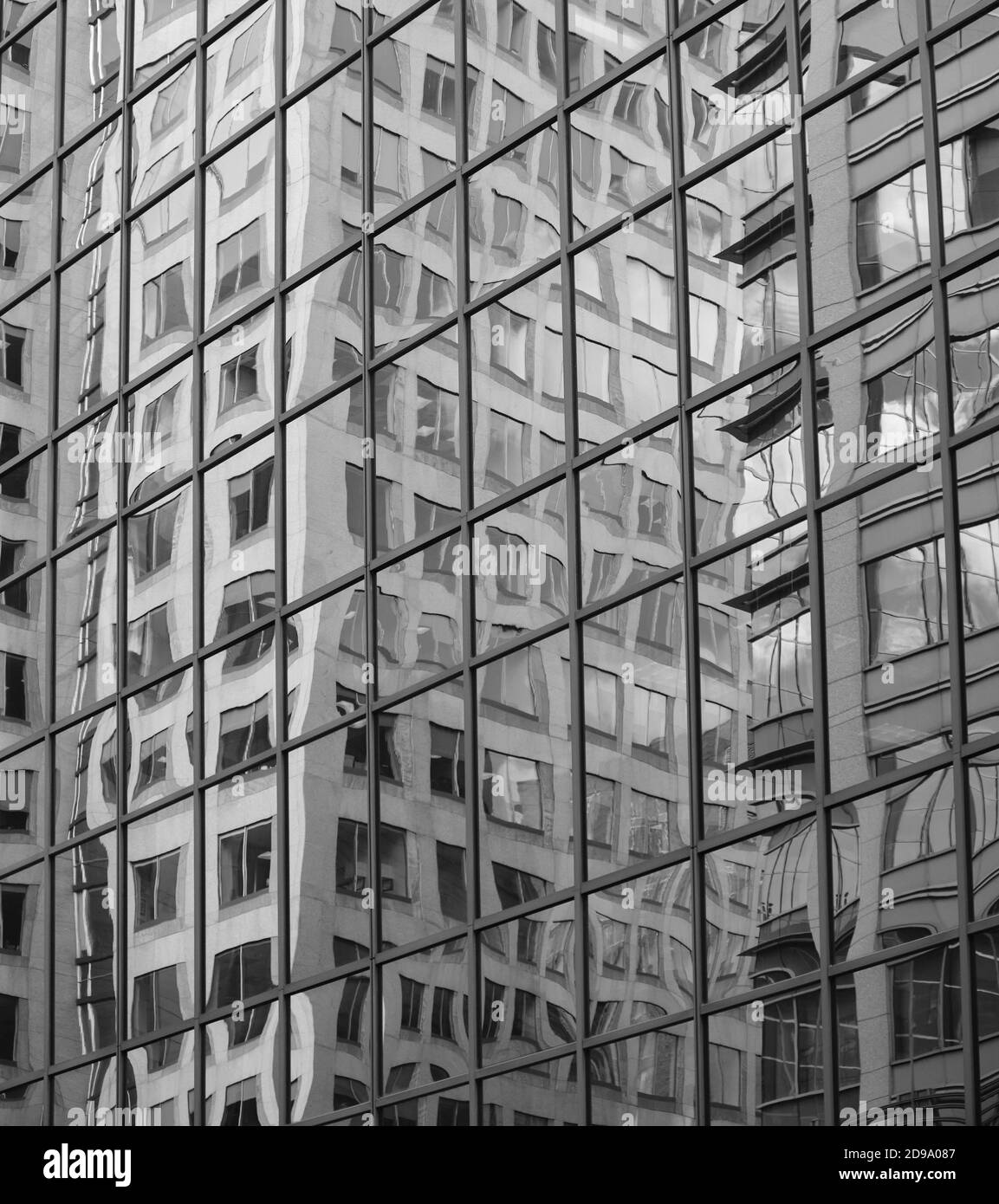 Bianco e nero edificio riflessioni su un edificio fatto di riquadri quadrati che fungono da specchi Foto Stock