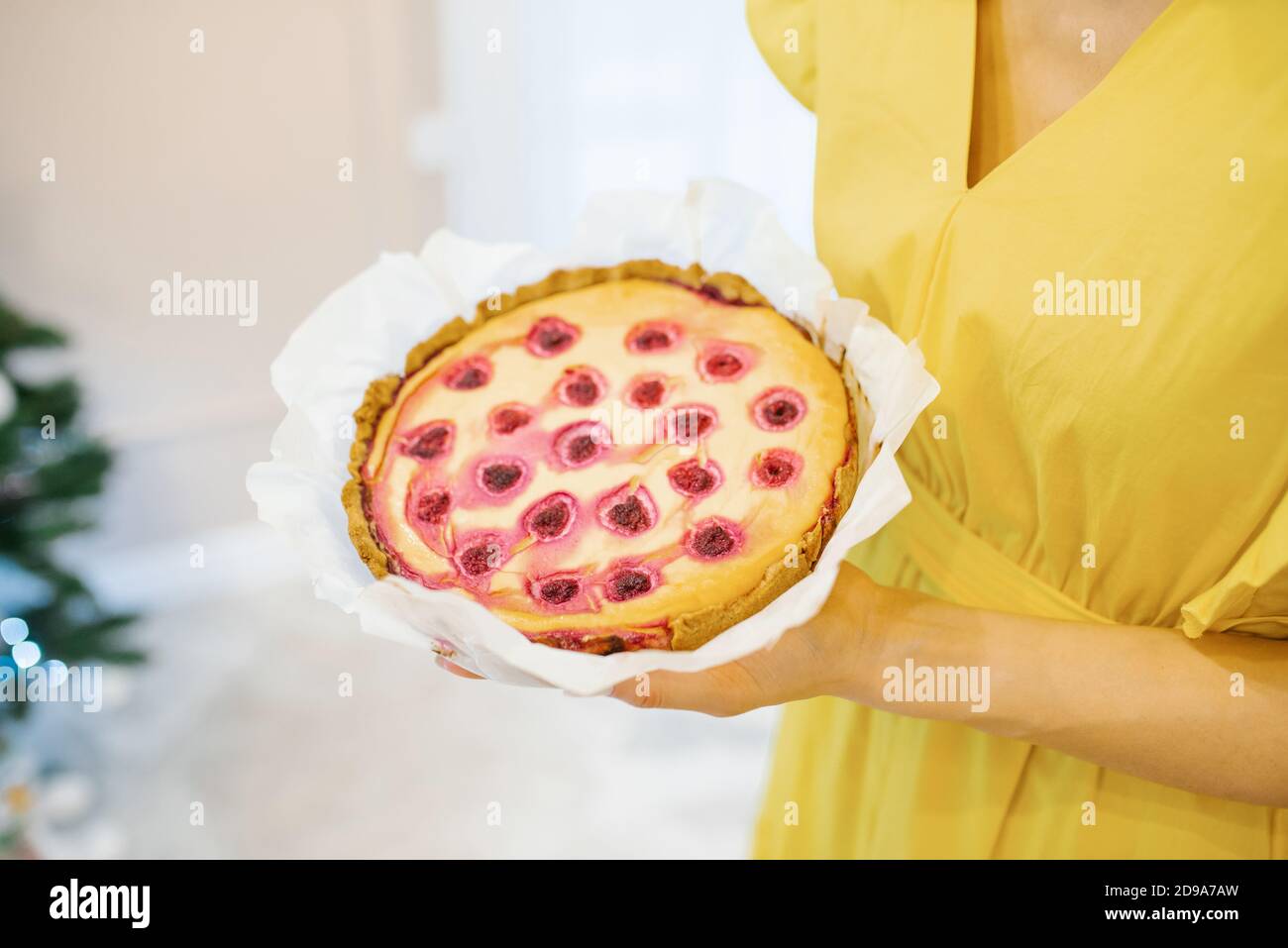Torta di ciliegia cotta nelle mani di una ragazza Foto Stock