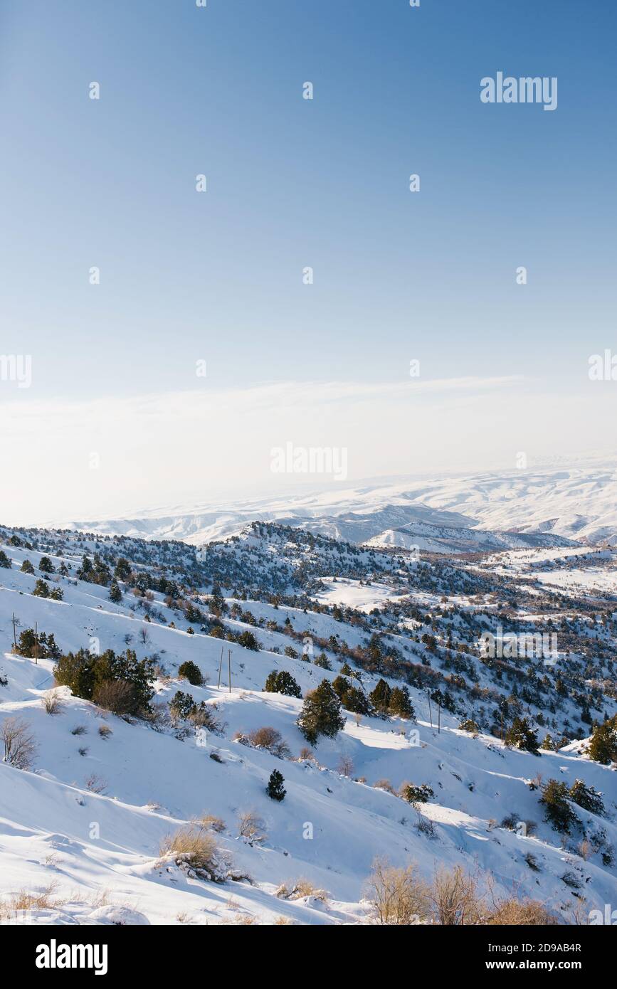 Panorama delle montagne di Tien Shan, che si apre dalla cima di un passo di montagna nella località di Beldersay in Uzbekistan Foto Stock