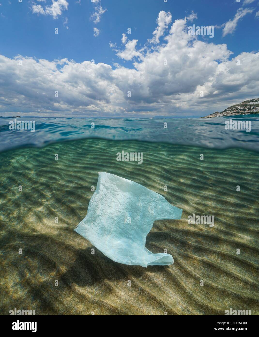 Inquinamento da rifiuti di plastica nell'oceano, una borsa di plastica sott'acqua e cielo blu nuvoloso, vista divisa sopra e sotto la superficie dell'acqua Foto Stock
