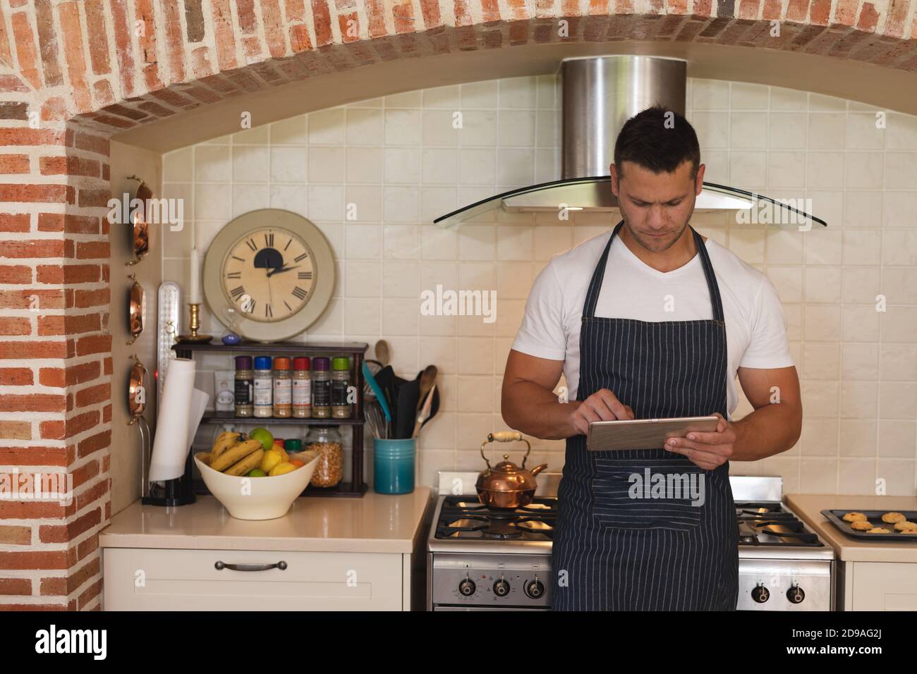 Uomo in un grembiule divertenti foto con arance in cucina Foto stock - Alamy