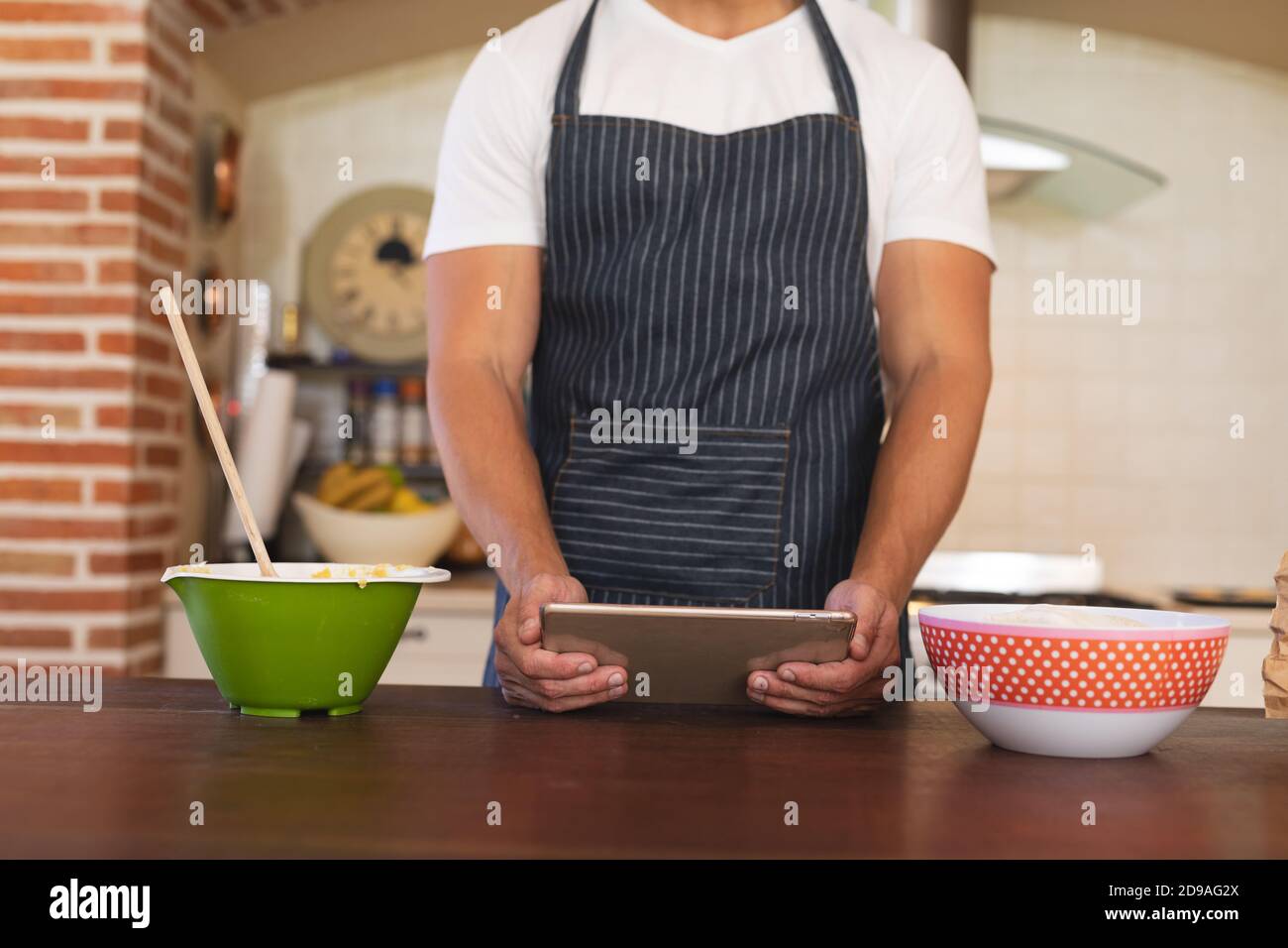 Uomo caucasico in piedi in una cucina e indossare grembiule Foto Stock