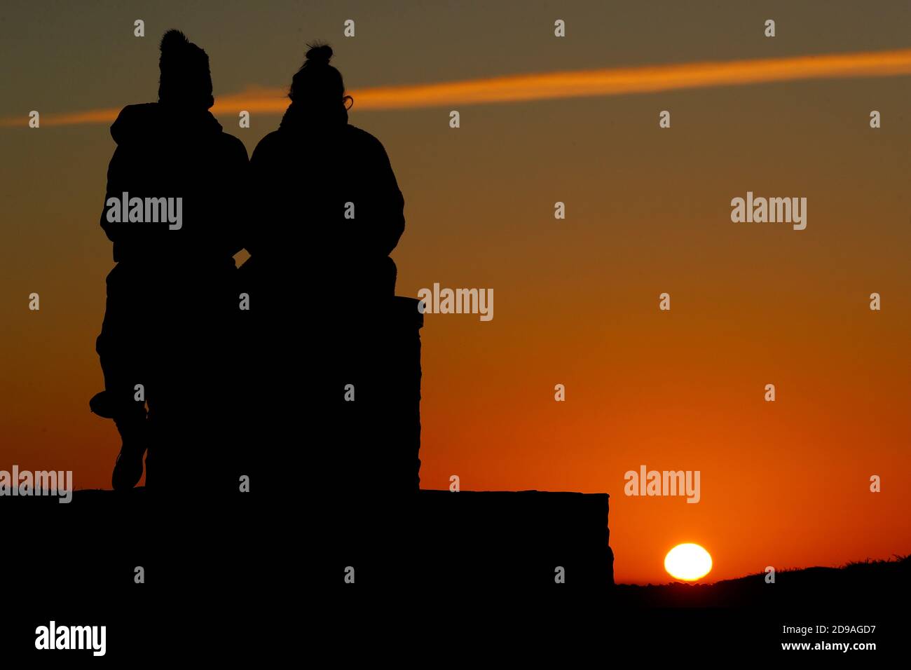 Newtown Linford, Leicestershire, Regno Unito. 4 novembre 2020. Meteo nel Regno Unito. Le donne guardano l'alba da Old John nel Bradgate Park. Credit Darren Staples/Alamy Live News. Foto Stock