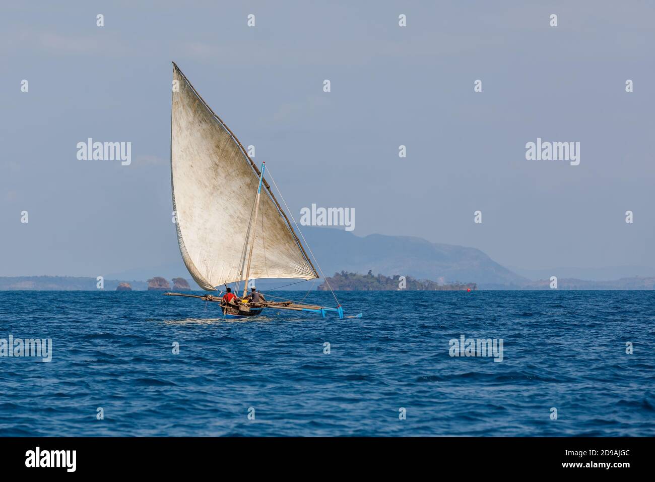 pescatore malgascio in mare in tradizionale dugout artigianale barca a vela in legno. La vita quotidiana sull'isola di Nosy Be. Nosy Be, Madagascar Foto Stock