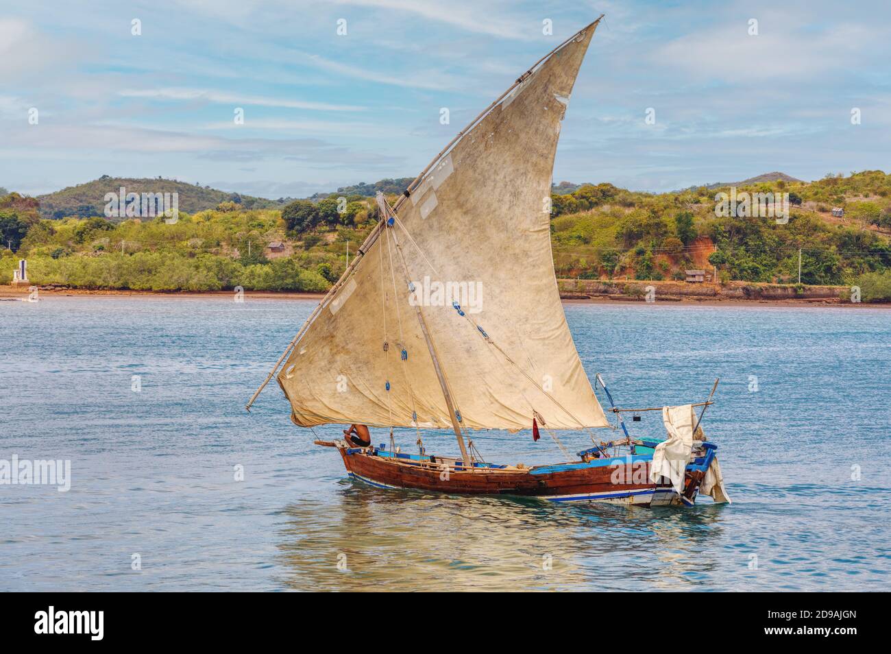 pescatore malgascio in mare in tradizionale dugout artigianale barca a vela in legno. La vita quotidiana sull'isola di Nosy Be. Nosy Be, Madagascar Foto Stock