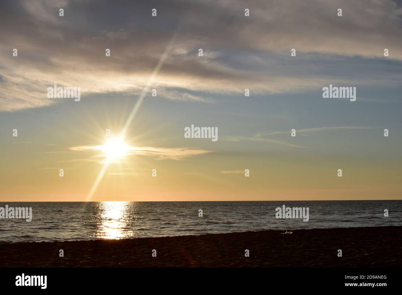 Un tramonto molto calmo e brillante sul Mar Tirreno vicino a Roma. Il sole si riflette sulla superficie del mare creando una luce superba che pervade l'intera immagine Foto Stock