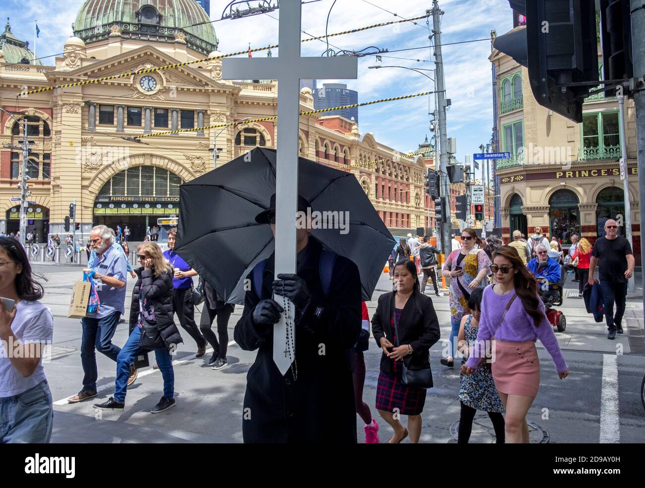 Un evangelista cristiano parata con la sua croce per le strade di Melbourne. Foto Stock