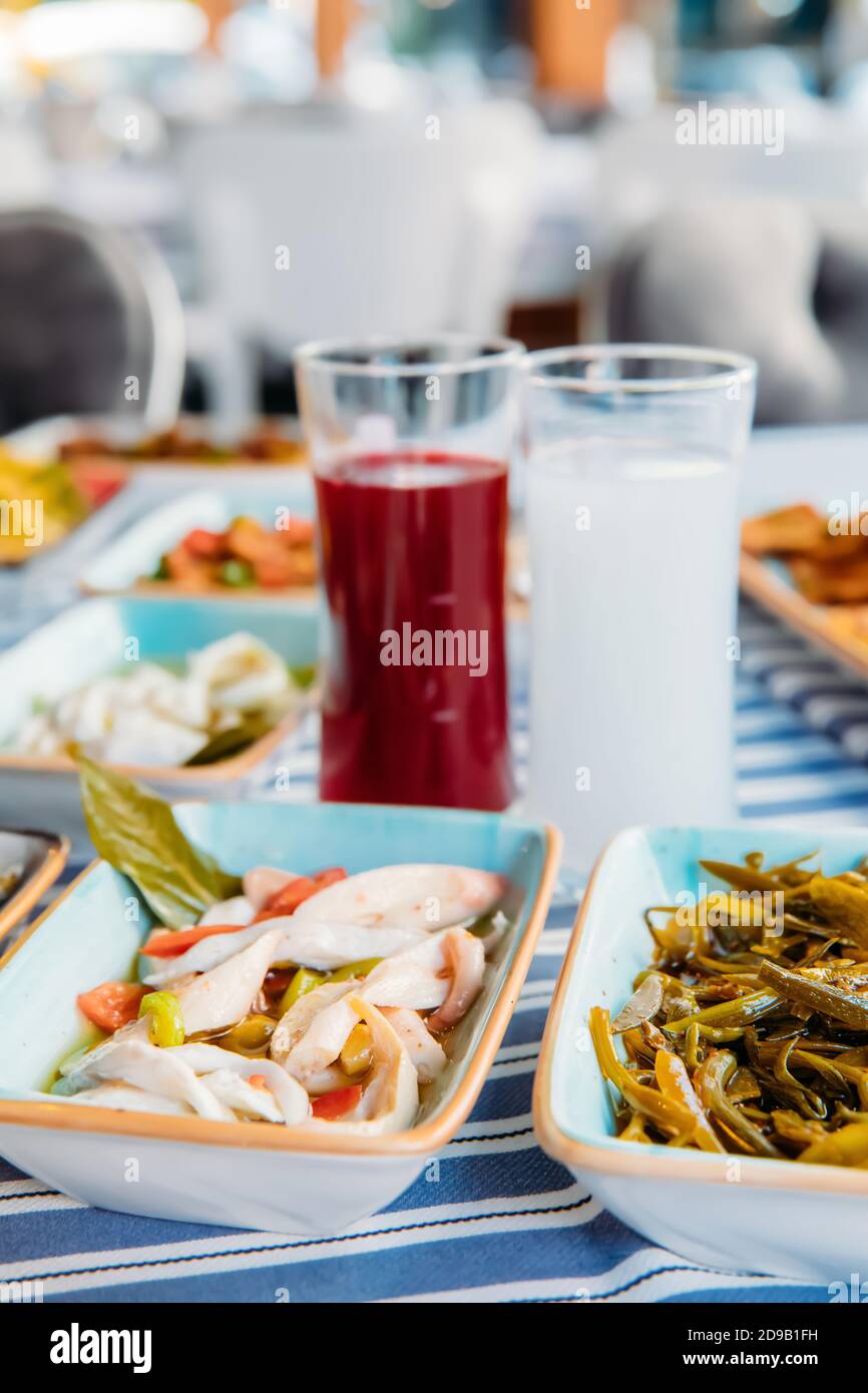 Pesce alla griglia, insalate e verdure. Frutti di mare, carne alla griglia, meze, raki, ouzo, Antipasti e insalate al tavolo nel ristorante di pesce greco o turco Foto Stock