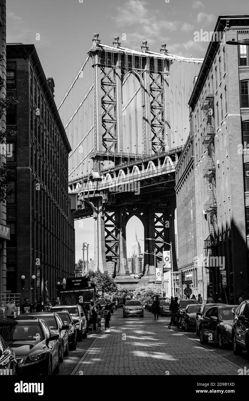 NEW YORK, USA - 22 settembre 2017: Immagine in bianco e nero del Manhattan Bridge con l'Empire state Building e gli edifici in mattoni a muro visti da Dumbo, Boro Foto Stock